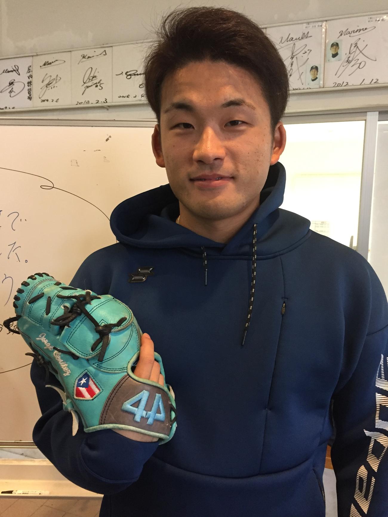 プエルトリコで物々交換したエメラルドグラブを持つロッテ山本（撮影・金子真仁）