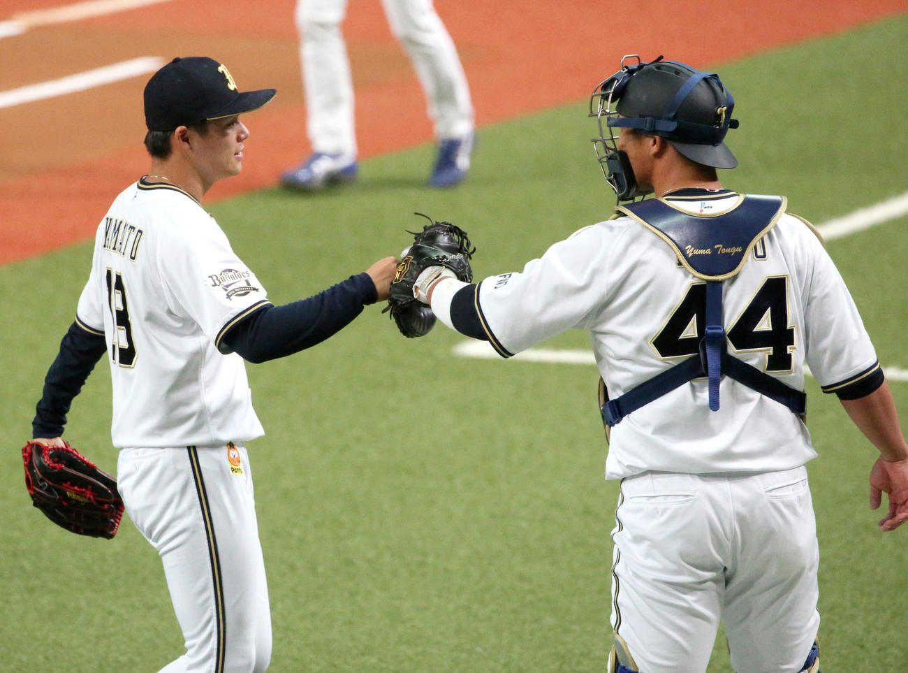 1回を三人で抑えた山本由伸（左）とタッチする捕手の頓宮裕真（撮影・上山淳一）