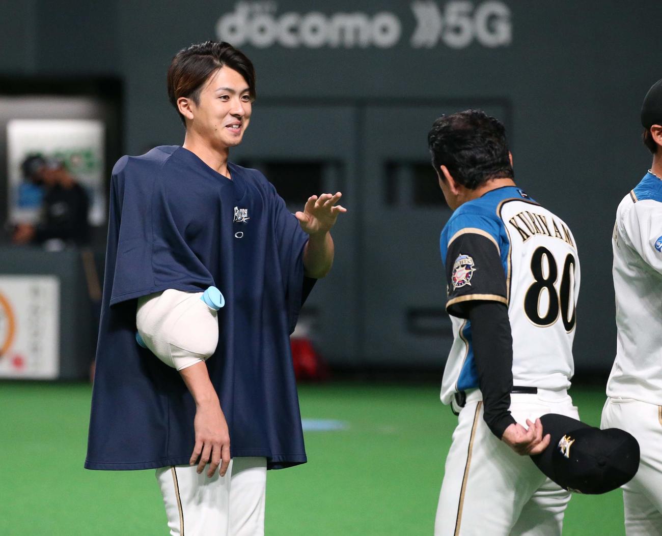 日本ハム対オリックス　試合後、栗山監督に出迎えられる上沢（撮影・黒川智章）