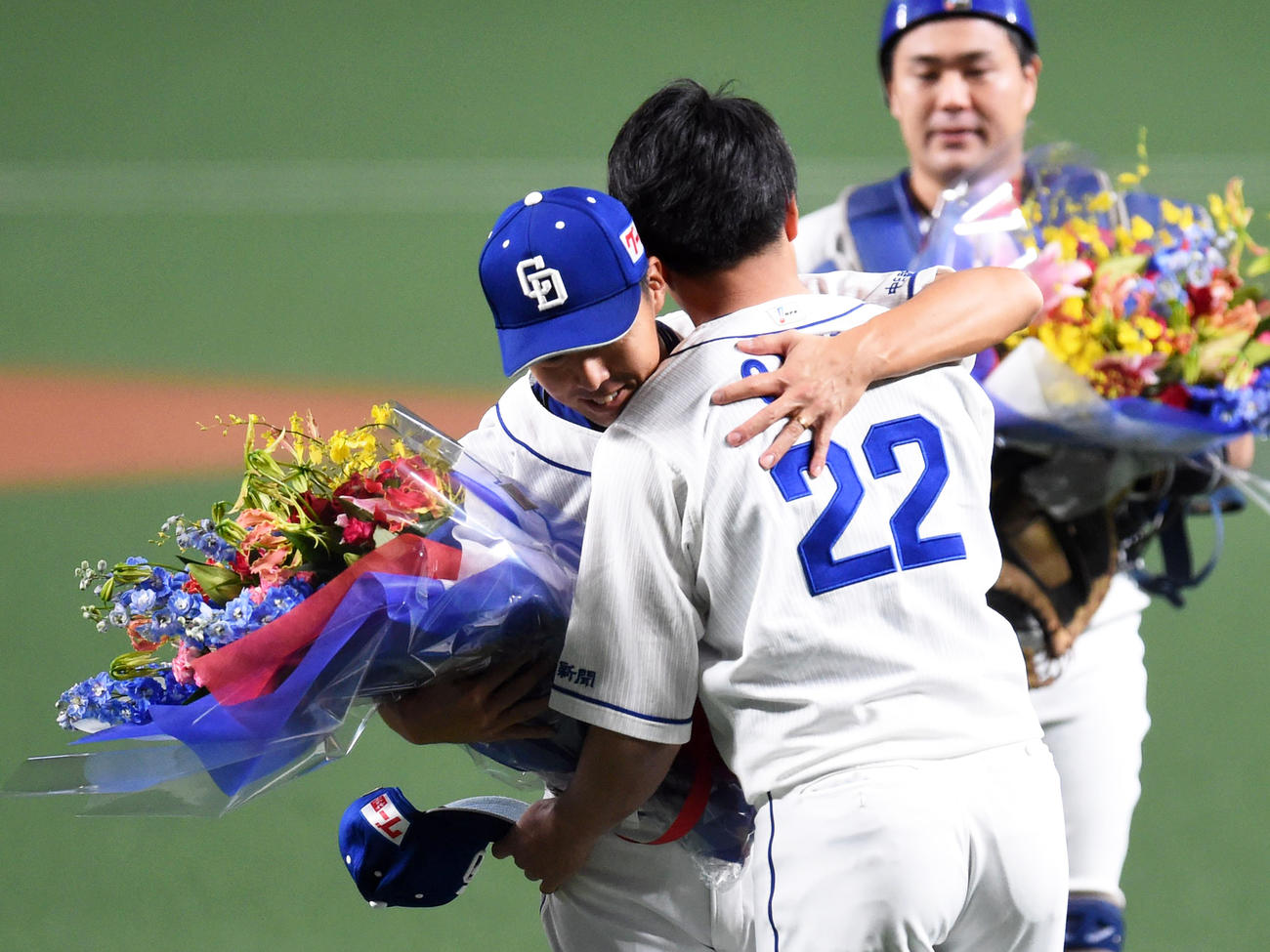 大野雄大（右）から花束を受け取りハグをする吉見一起（撮影・森本幸一）