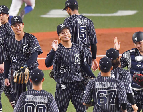初セーブを挙げナインとハイタッチして喜ぶ漆原大晟（中央）（2020年8月23日撮影）