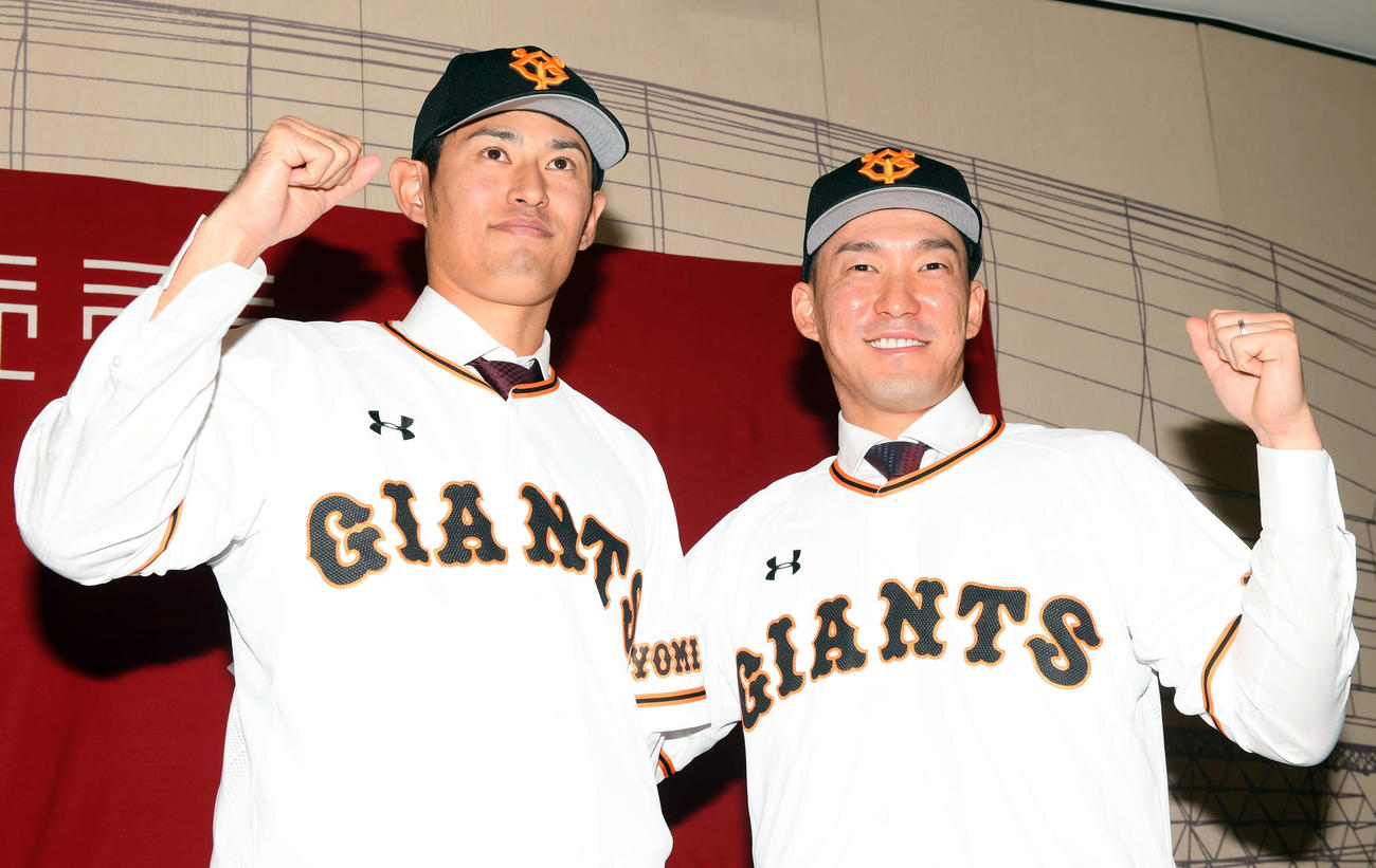 巨人の入団会見で笑顔でポーズを決める井納（左）と梶谷（撮影・たえ見朱実）