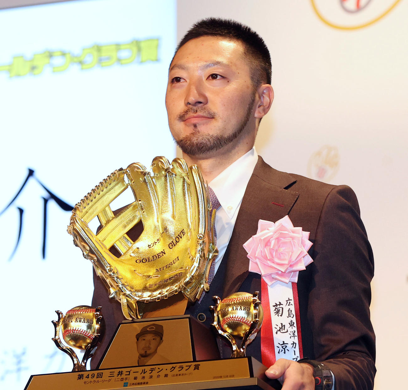 「三井ゴールデン・グラブ賞」を受賞し、トロフィーを持つ菊池涼（撮影・狩俣裕三）