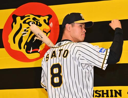 新人選手入団発表会でバットを背に背番号8を披露する佐藤輝（2020年12月7日）
