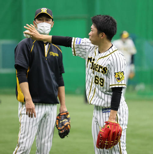 金村暁投手コーチ（左）の前で変化球の練習を行う石井大智（撮影・清水貴仁）