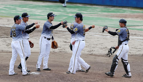 ウエスタンリーグ中日対阪神　9回裏中日2死、浜地（中央右）は石岡を三振に仕留めで勝利しナインとマウンドでタッチする（撮影・加藤哉）