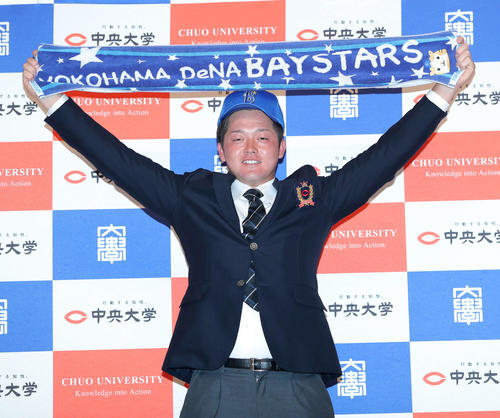 2020年10月26日　タオルを掲げキャップを被り写真に納まるDeNA2位指名の中大・牧