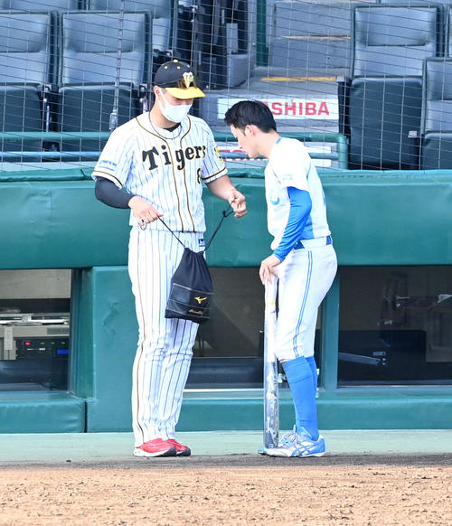 ４日に行われた高田クラブとの試合で、阪神佐藤輝（左）は近大の同級生の岡にバットなどをプレゼント（撮影・前岡正明）