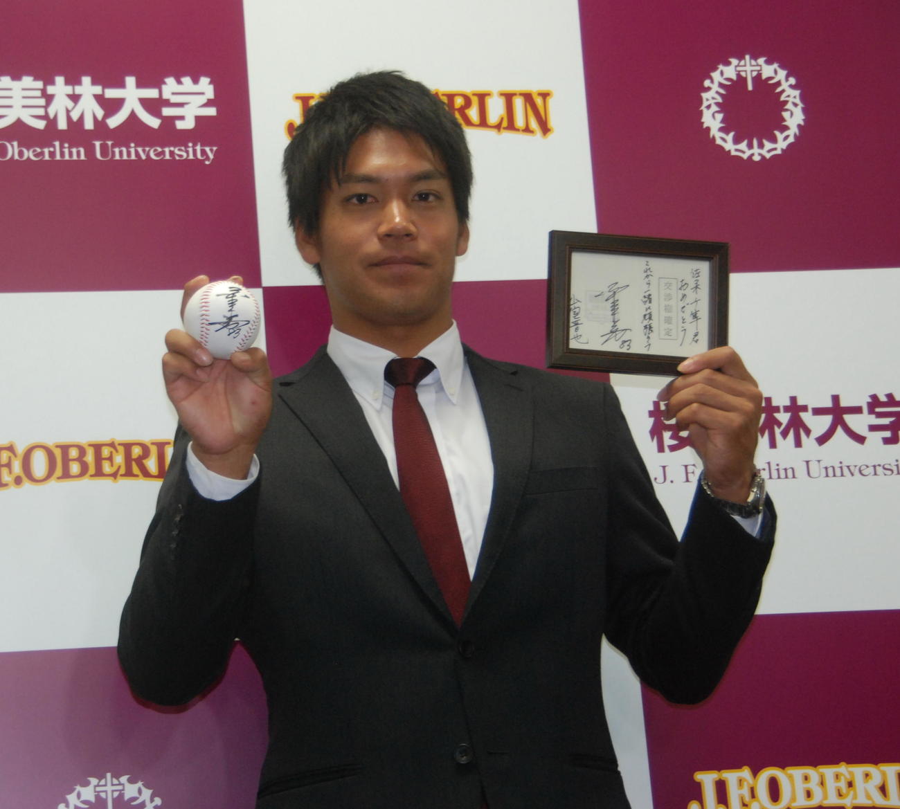 伊東監督のサインが入ったボールと交渉権獲得の紙を手にするロッテのドラフト1位、桜美林大・佐々木（2016年10月24日撮影）