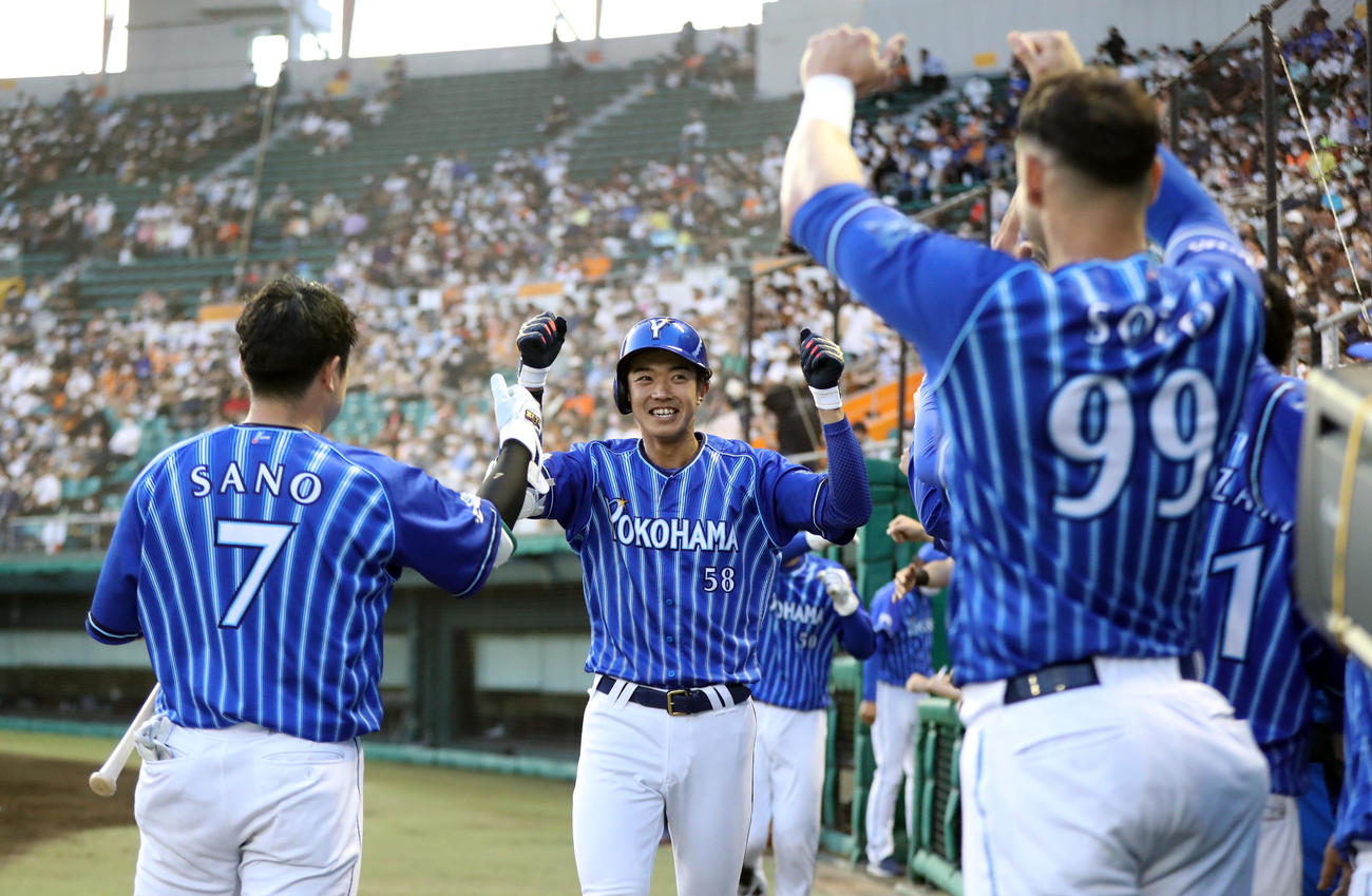 巨人対DeNA 3回表DeNA1死二塁、プロ初本塁打となる2点本塁打を放ち、ナインに迎えられる梶原（中央）（2022年4月12日撮影）