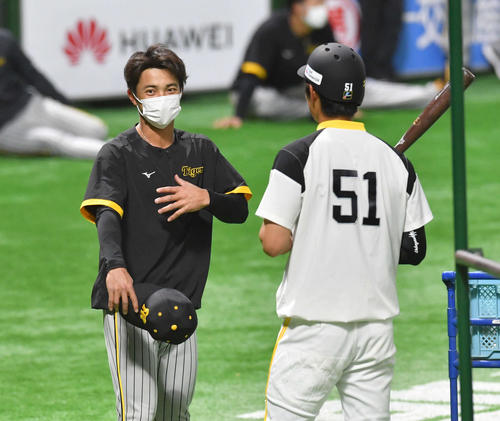 ソフトバンク対阪神　試合前、ソフトバンク上林（右）と話す阪神熊谷（2022年3月15日撮影）