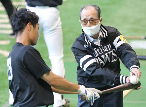27日、王球団会長（右）から打撃指導を受ける渡辺