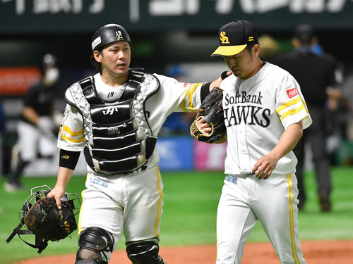 ソフトバンク対日本ハム　延長10回表、悪送球で日本ハムに勝ち越しを許し、肩を落としてベンチへ戻る嘉弥真（右）。左は甲斐（撮影・岩下翔太）