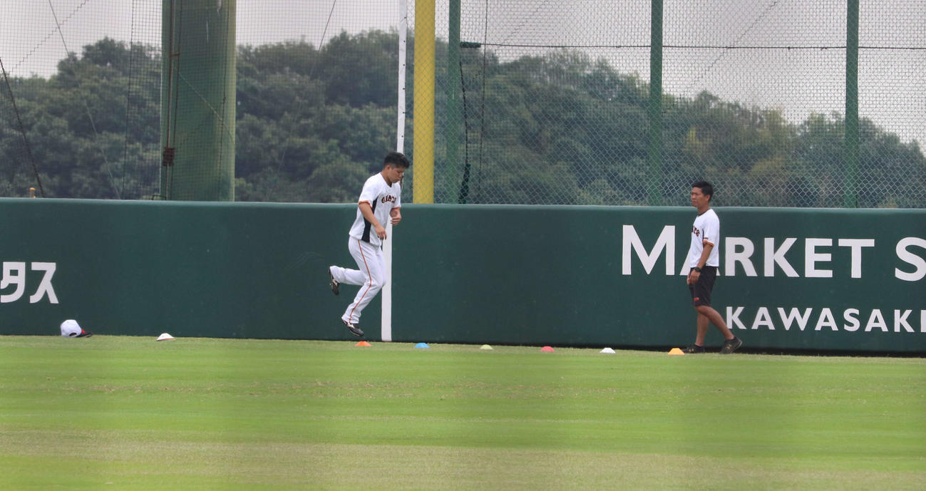 ジャイアンツ球場の外野で1人、別メニューで“特別トレーニング”を行う巨人大城（左）と石森2軍トレーニングコーチ（2022年6月11日撮影）