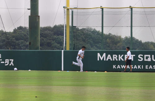 ジャイアンツ球場の外野で1人、別メニューで“特別トレーニング”を行う巨人大城（左）と石森2軍トレーニングコーチ（2022年6月11日撮影）