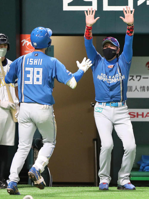 勝ち越し本塁打に万歳して石井を迎える日本ハム新庄監督（撮影・梅根麻紀）
