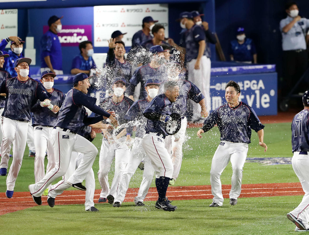 DeNA対阪神　9回裏DeNA2死一、二塁、嶺井（中央）は右前にサヨナラ適時打を放ち水シャワーで祝福される（2022年6月30日撮影）
