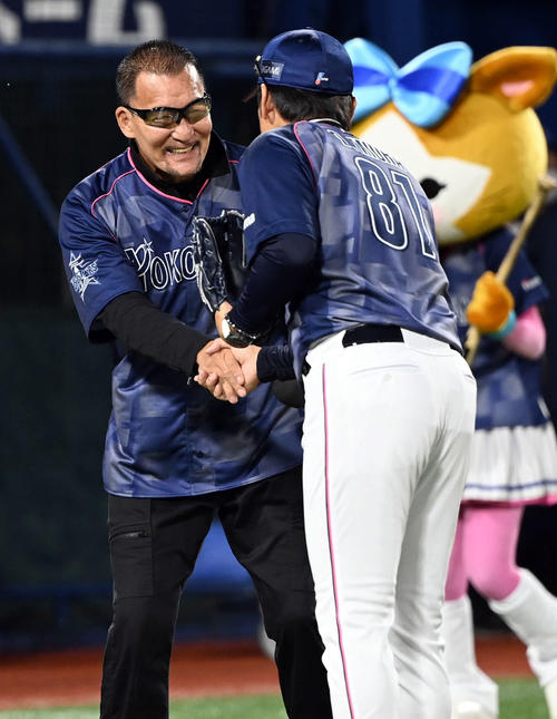21日、始球式でプロレスラーの蝶野正洋との対決を終え握手を交わすDeNA三浦監督