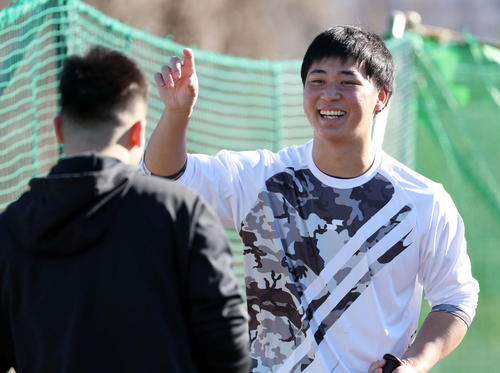 新人自主トレを公開した阪神井坪（右）は八王子リトルシニア時代の同級生と笑顔で野球談議する（2022年12月27日撮影）