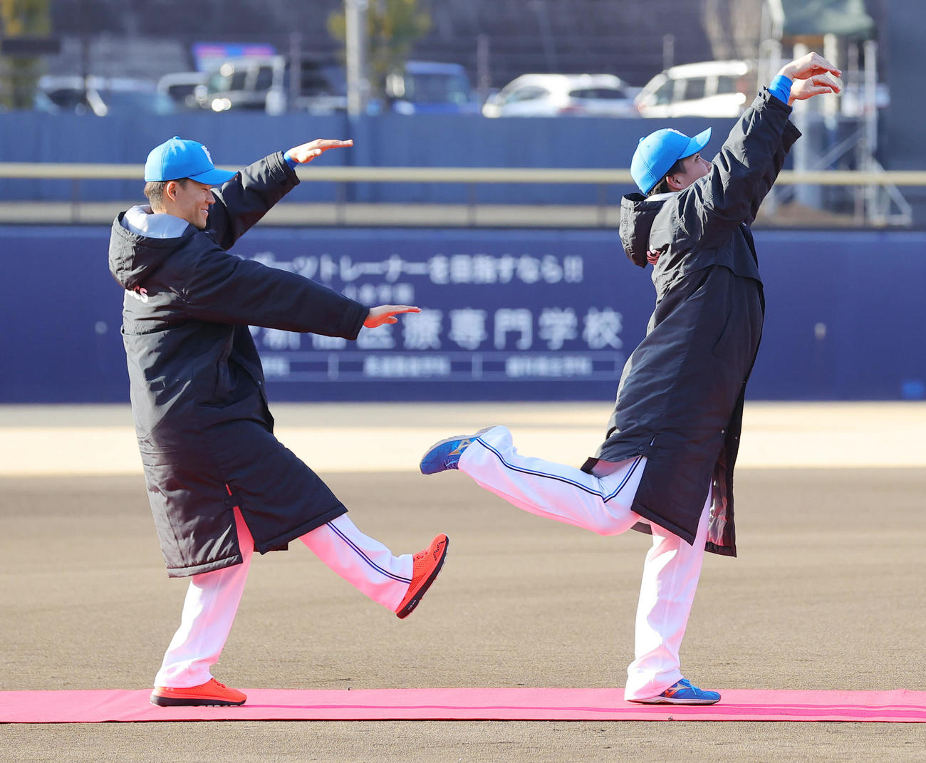 日本ハムの新人お披露目会で、人文字で新球場「エスコンフィールド（ES CON FIELD）」を披露する左からE担当の矢沢、S担当の金村（2023年1月22日撮影）