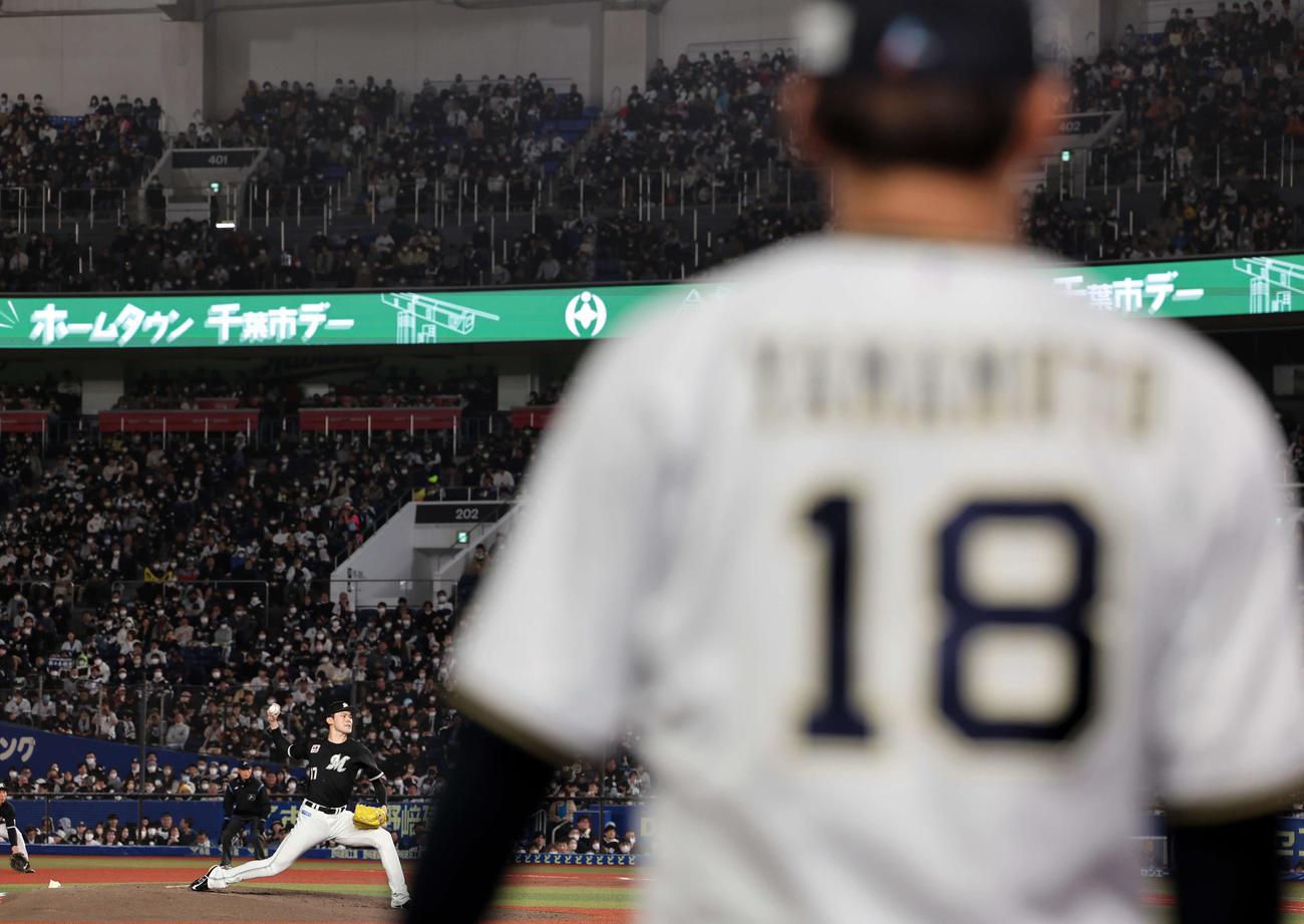 ロッテ対オリックス　オリックス山本（手前）が見つめる中、力投するロッテ佐々木朗（撮影・浅見桂子）