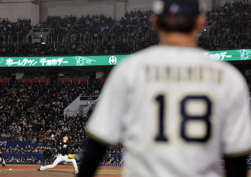 ロッテ対オリックス　オリックス山本（手前）が見つめる中、力投するロッテ佐々木朗（撮影・浅見桂子）