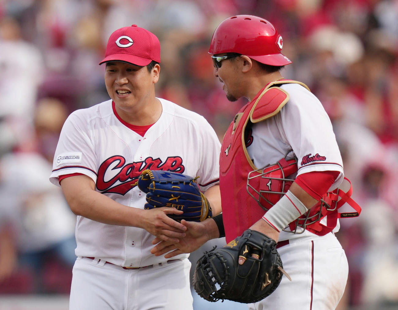 6月24日、巨人戦の試合後に会沢と握手を交わす矢崎（左）