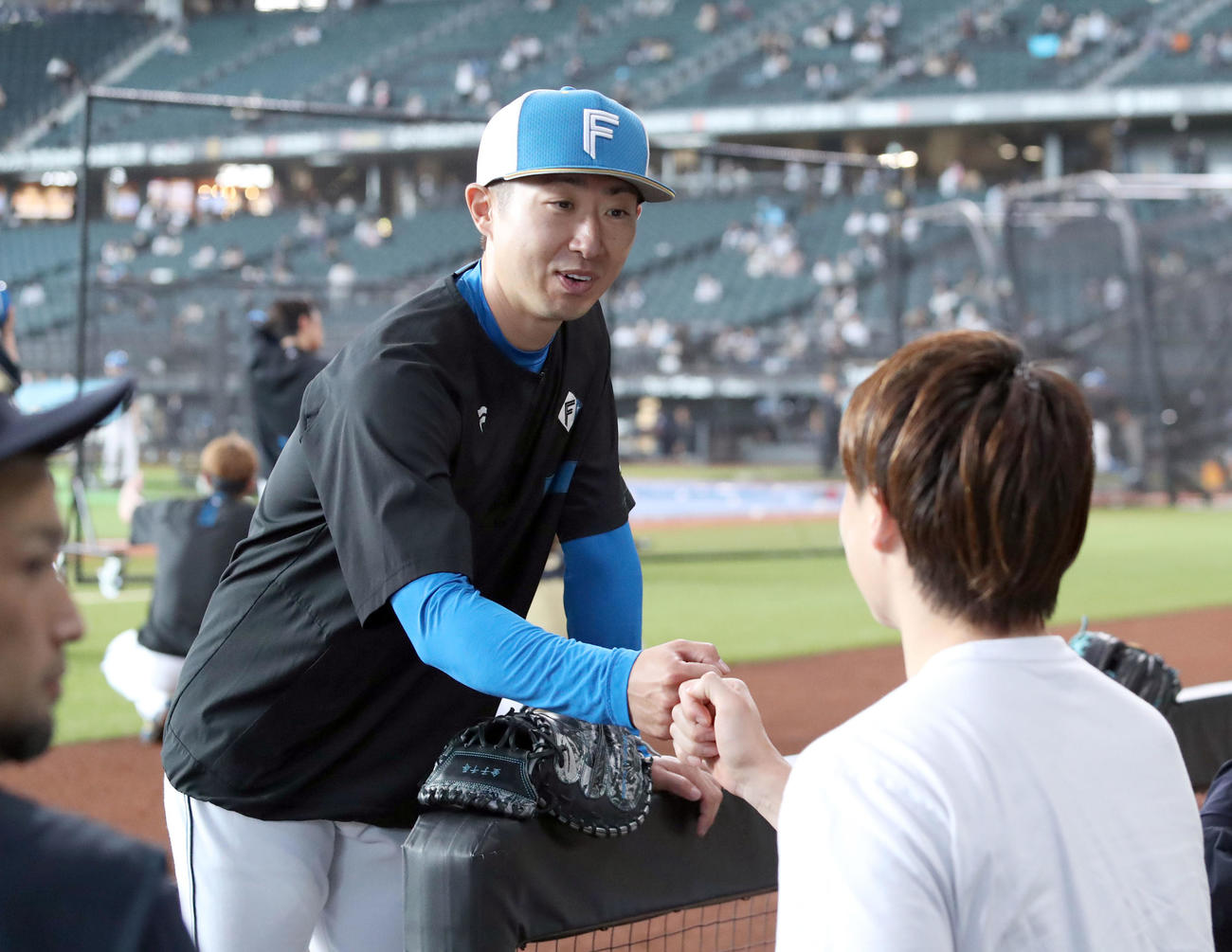 7月1日、オリックスベンチを訪れた日本ハム金子特命コーチ（左）は山崎福とグータッチを交わす（撮影・佐藤翔太）