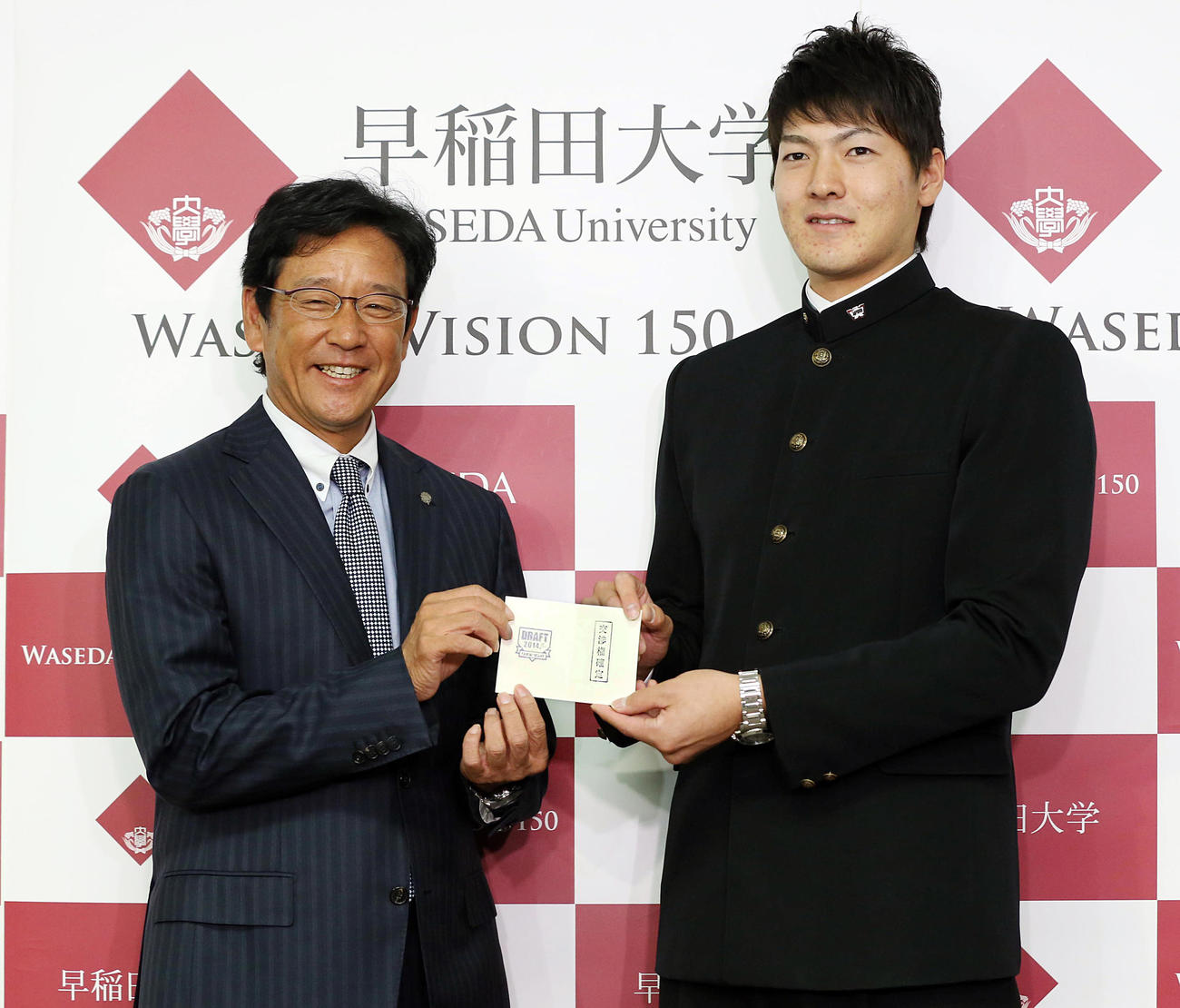 2014年11月、日本ハムの栗山監督から指名あいさつを受けた早大の有原（右）は、交渉権獲得の当たりクジを手渡され笑顔を見せる