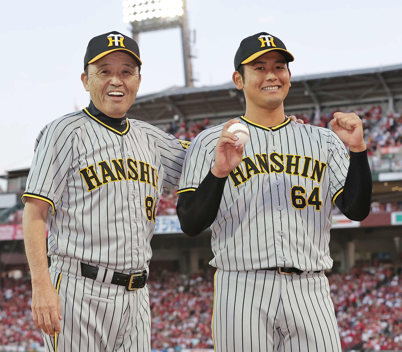 1日、プロ初勝利をあげた岡留（右）は岡田監督の祝福に笑顔を見せる