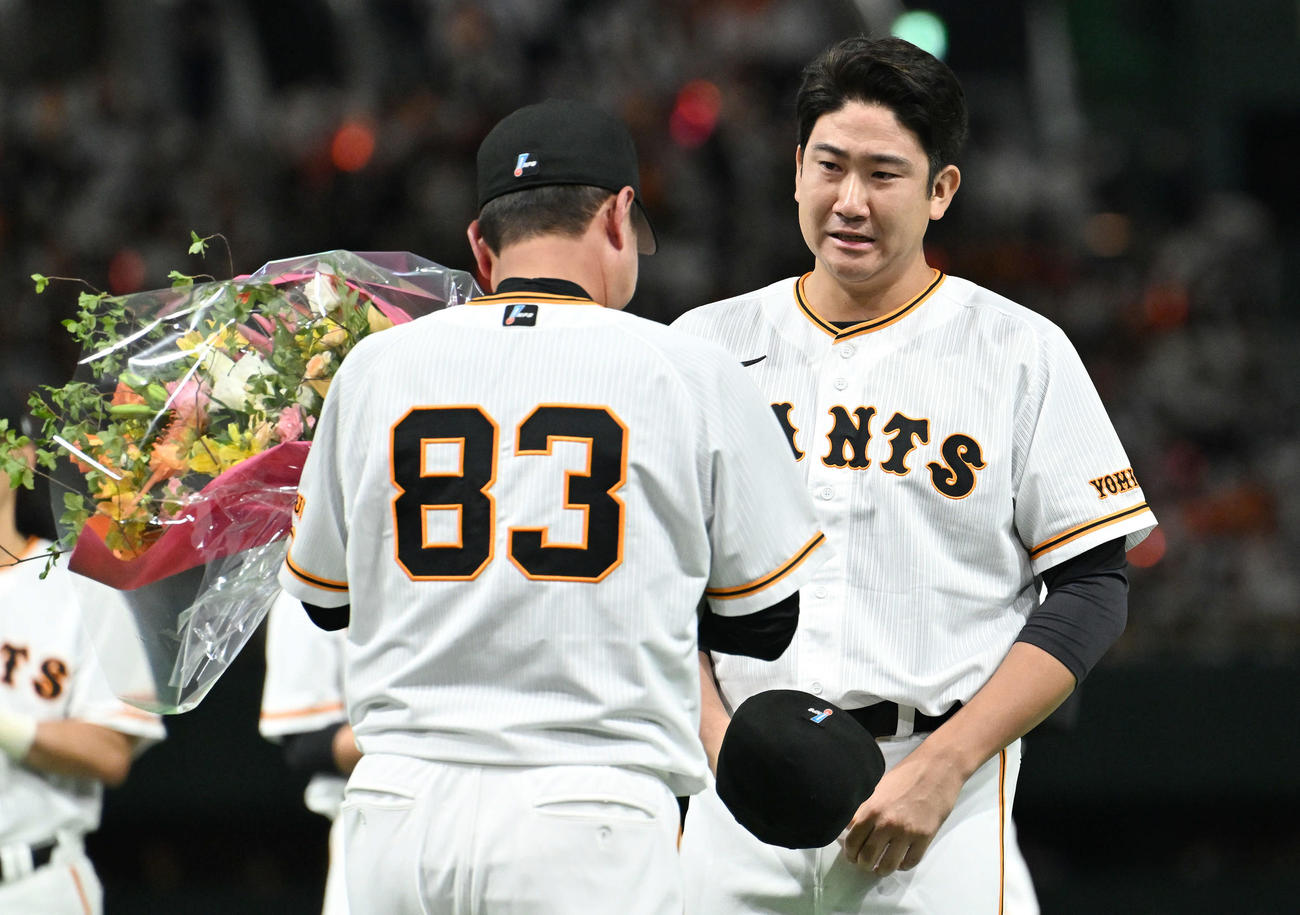 10月4日、最終戦セレモニーで退任する巨人原監督（手前）に涙ながらに花束を渡す菅野