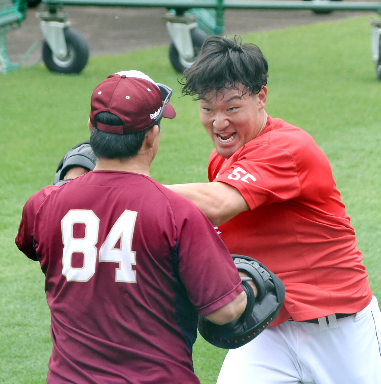 楽天雄平コーチ（手前）が持つミットに強烈なパンチを打ち込む安田（撮影・山田愛斗）