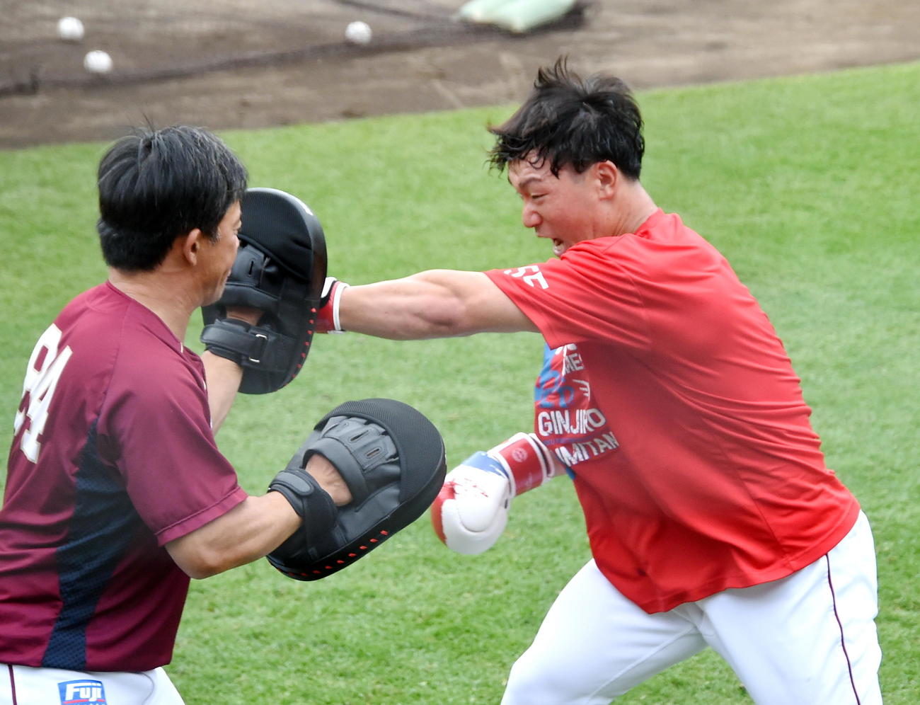 楽天雄平コーチ（左）が持つミットに強烈なパンチを打ち込む安田（撮影・山田愛斗）