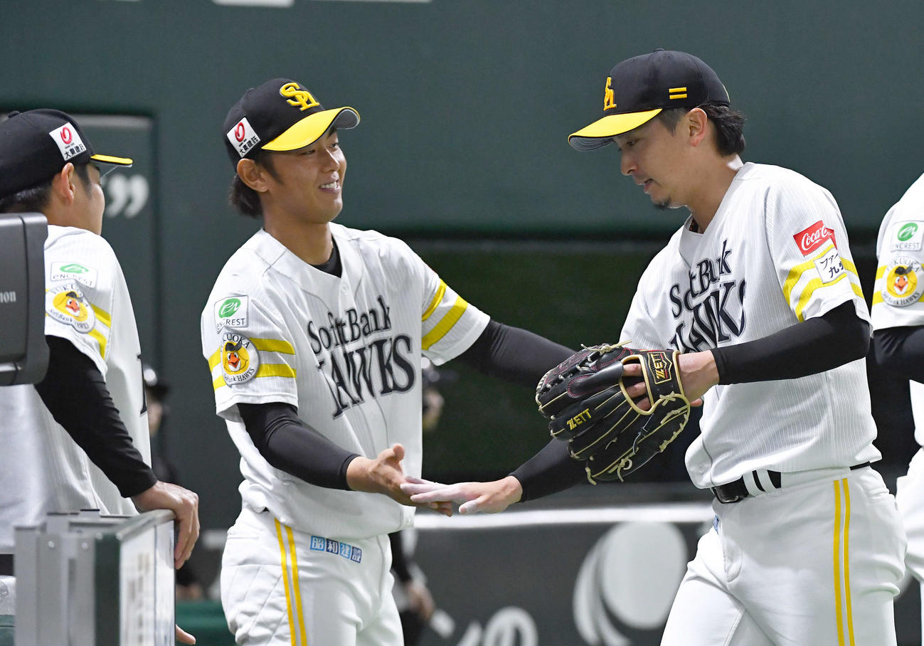 ソフトバンク対阪神　7回途中無失点で降板となり、今宮（左から2人目）らナインとタッチを交わしてベンチへ戻る東浜（撮影・岩下翔太）