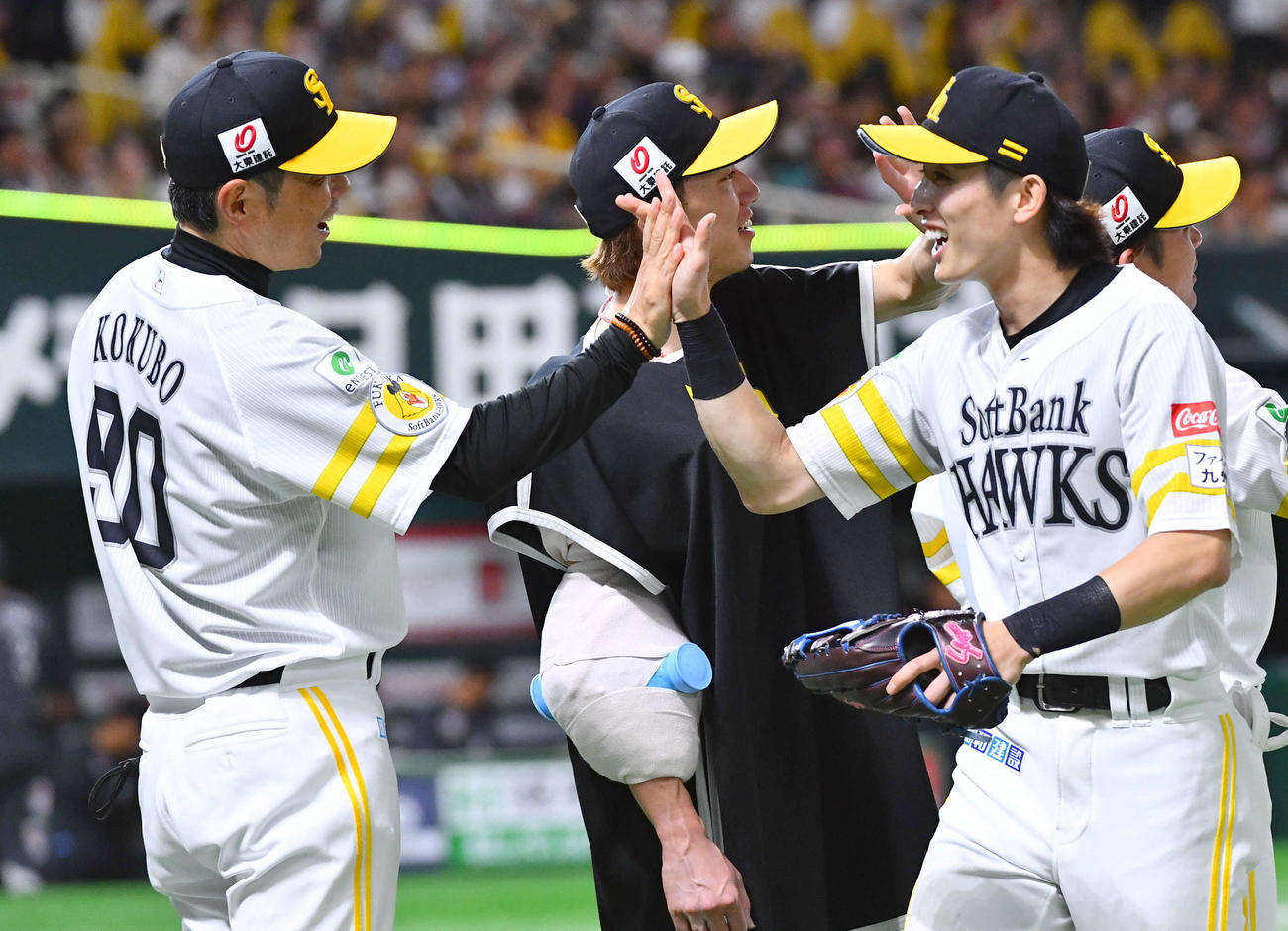 ソフトバンク対ロッテ　ロッテに勝利し、周東（右）らナインとタッチを交わす小久保監督（左）と大津（撮影・岩下翔太）
