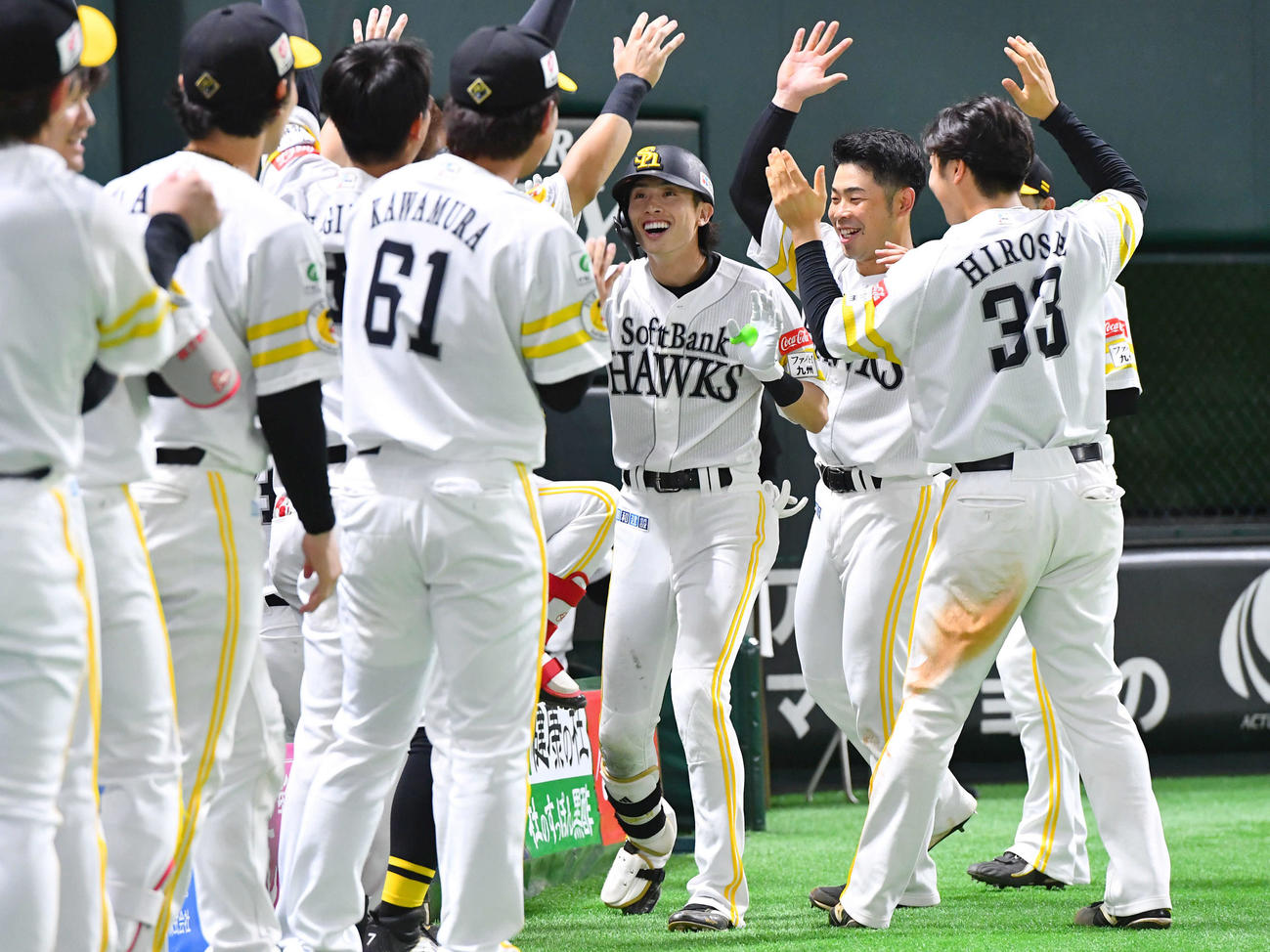ソフトバンク対ロッテ　8回裏ソフトバンク2死、右中間へ勝ち越し本塁打を放った周東（中央）は、ナインからの祝福に笑顔を見せる（撮影・岩下翔太）