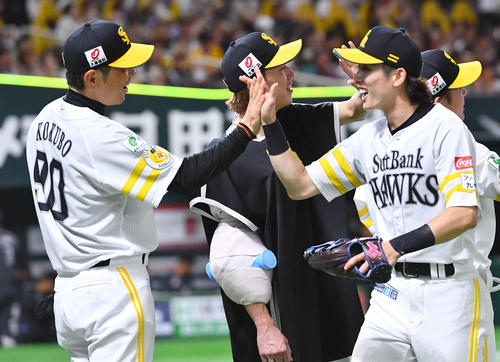 ソフトバンク対ロッテ　ロッテに勝利し、周東（右）らナインとタッチを交わす小久保監督（左）と大津（撮影・岩下翔太）