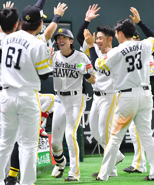 ソフトバンク対ロッテ　8回裏ソフトバンク2死、右中間へ勝ち越し本塁打を放った周東（中央）は、ナインからの祝福に笑顔を見せる（撮影・岩下翔太）