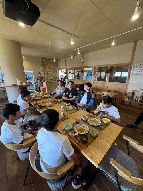 Hanshin Chikamoto (center right) holds a luncheon for children on Okinoerabu Island (provided by⁤ LINK UP representative director Ishii)