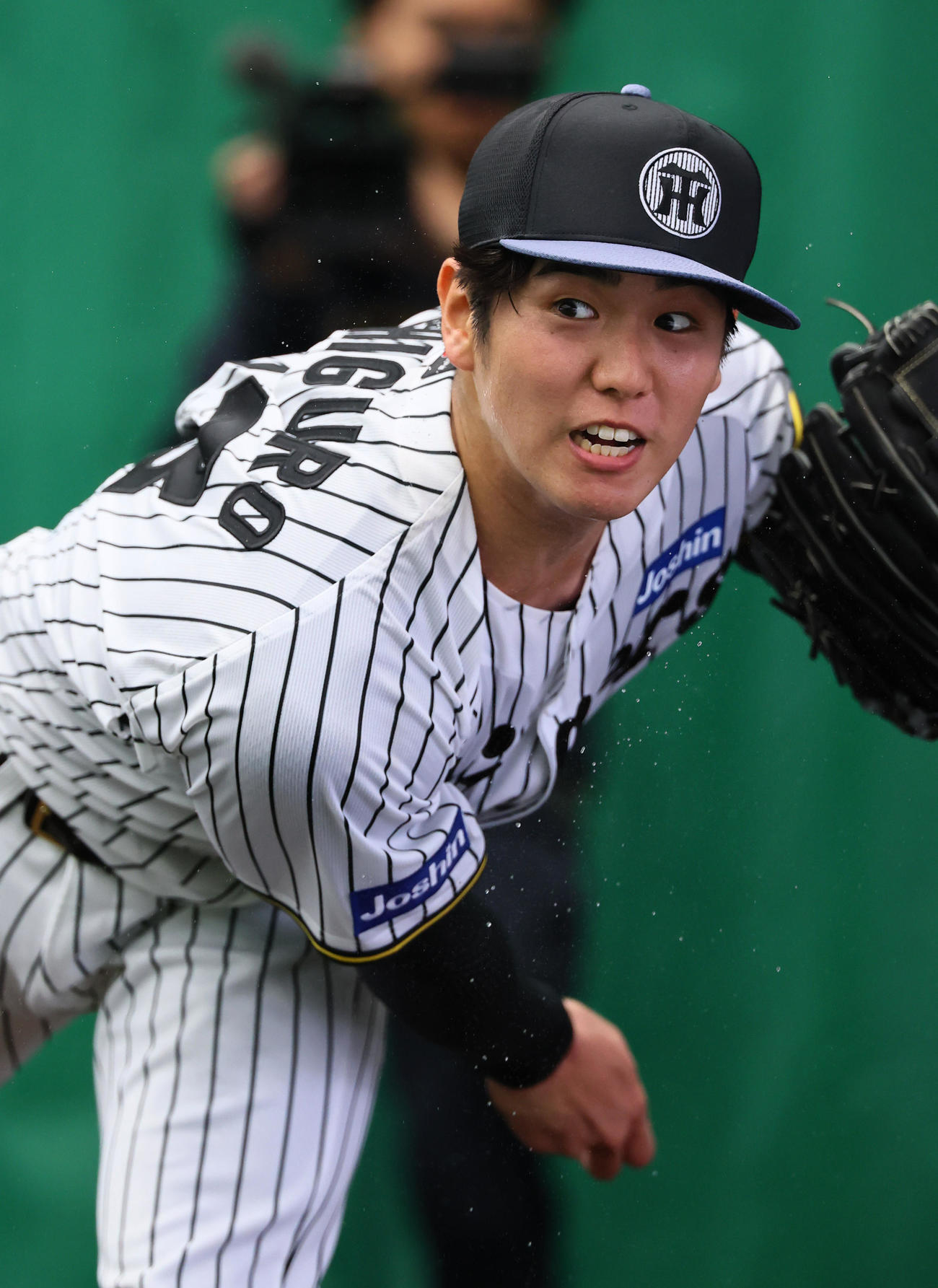 汗を飛ばしブルペンで投球練習をする石黒（撮影・藤尾明華）