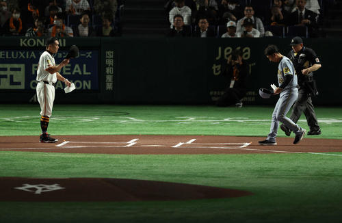 2025年4月4日巨人対阪神　開始前円、メンバー表交換する巨人阿部監督（左）と阪神藤川監督