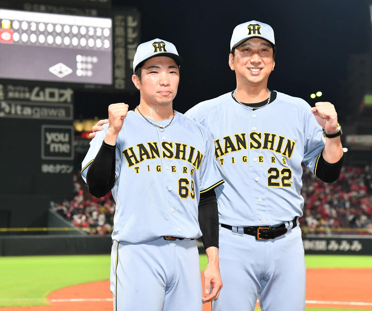 広島対阪神　セリーグ新記録となる39試合連続無失点を達成した阪神石井（左）は藤川監督と写真に納まる（撮影・岩下翔太）
