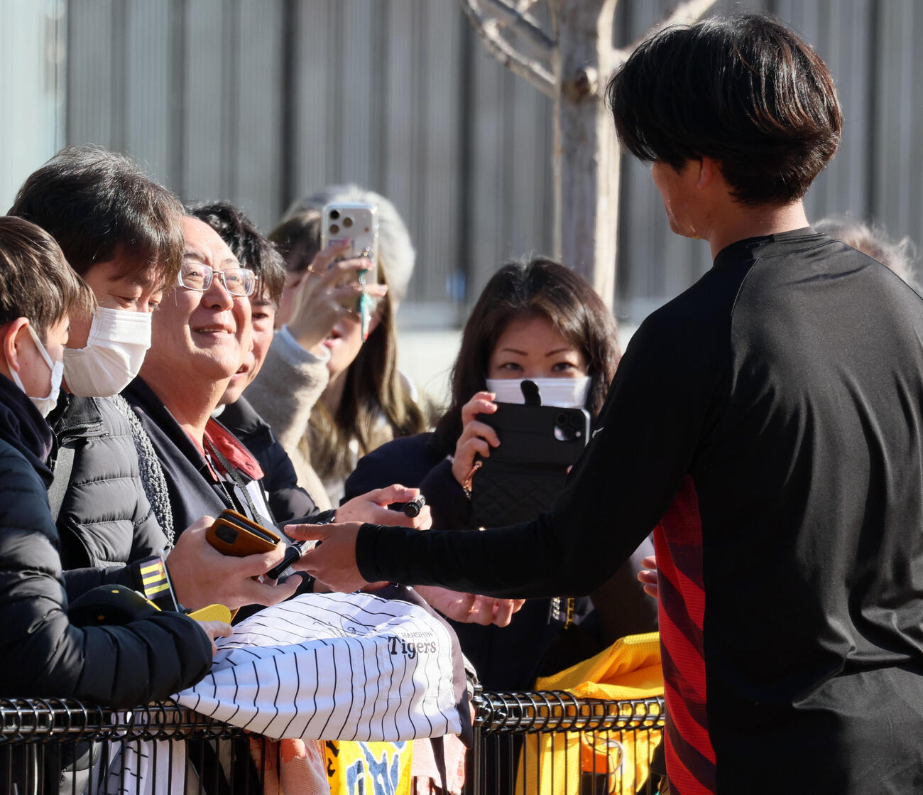 阪神自主トレを見学に訪れたタレントの松村邦洋氏（左）はファンの列に並んで阪神高橋と言葉をかわす（2026年1月撮影）