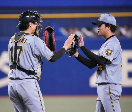 中日対阪神　完封勝利し伏見寅威（左）とタッチを交わす阪神高橋遥人（撮影・森本幸一）