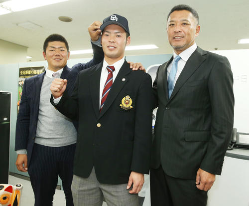 14年11月、父の近藤真市コーチ（右）の横でガッツポーズする中日育成4位の近藤。左は清水スカウト