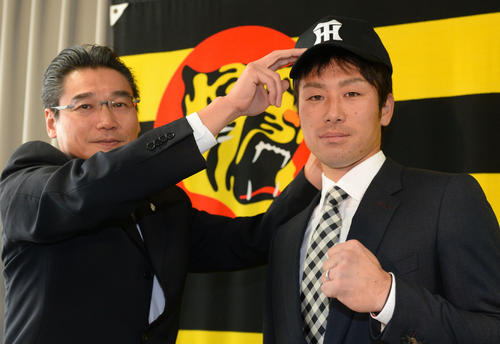 17年11月、阪神入団発表で、嶌村聡球団副本部長(左)から帽子をかぶせてもらう山崎憲晴