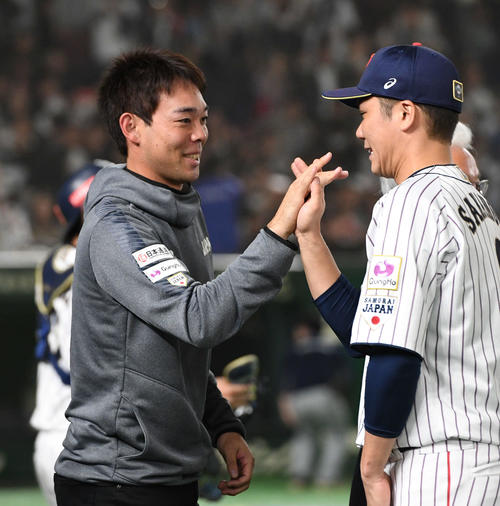 日本対韓国　タッチをかわして勝利を喜ぶ秋山（左）と坂本勇（撮影・山崎安昭）