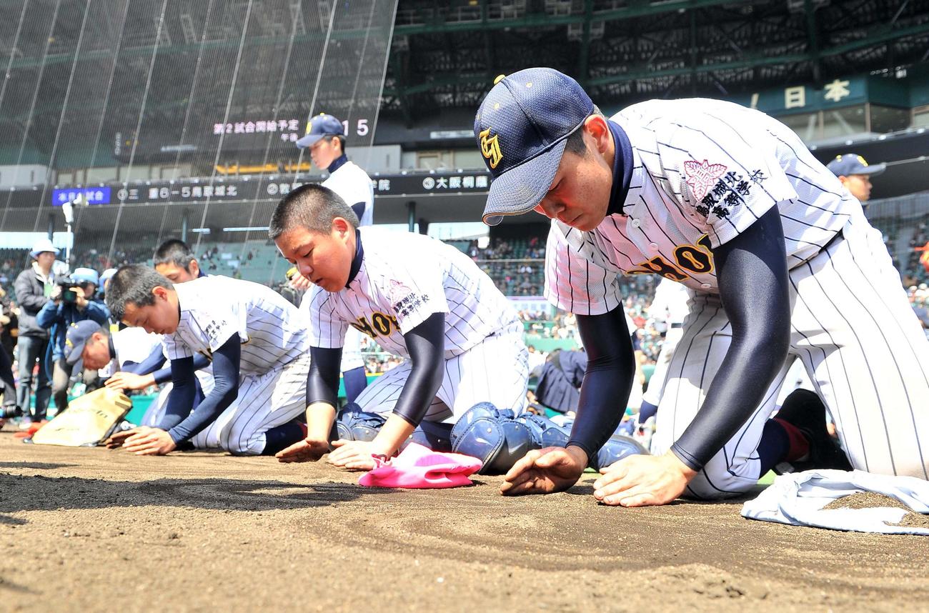 12年3月、センバツ甲子園で三重に敗れ甲子園の砂を集める鳥取城北ナイン