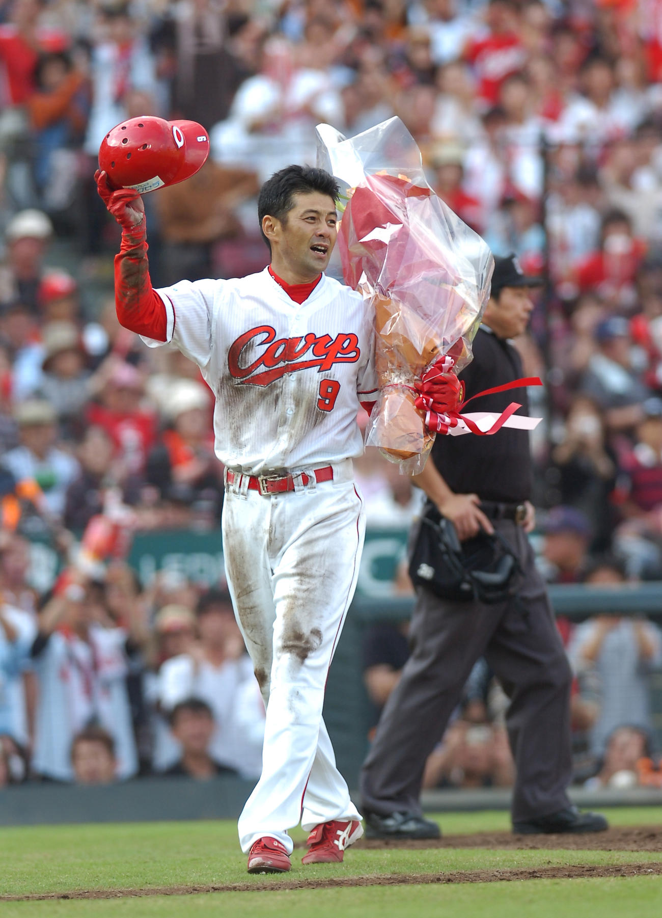 09年10月、巨人戦での引退試合で花束を手にファンの声援に応える緒方孝市
