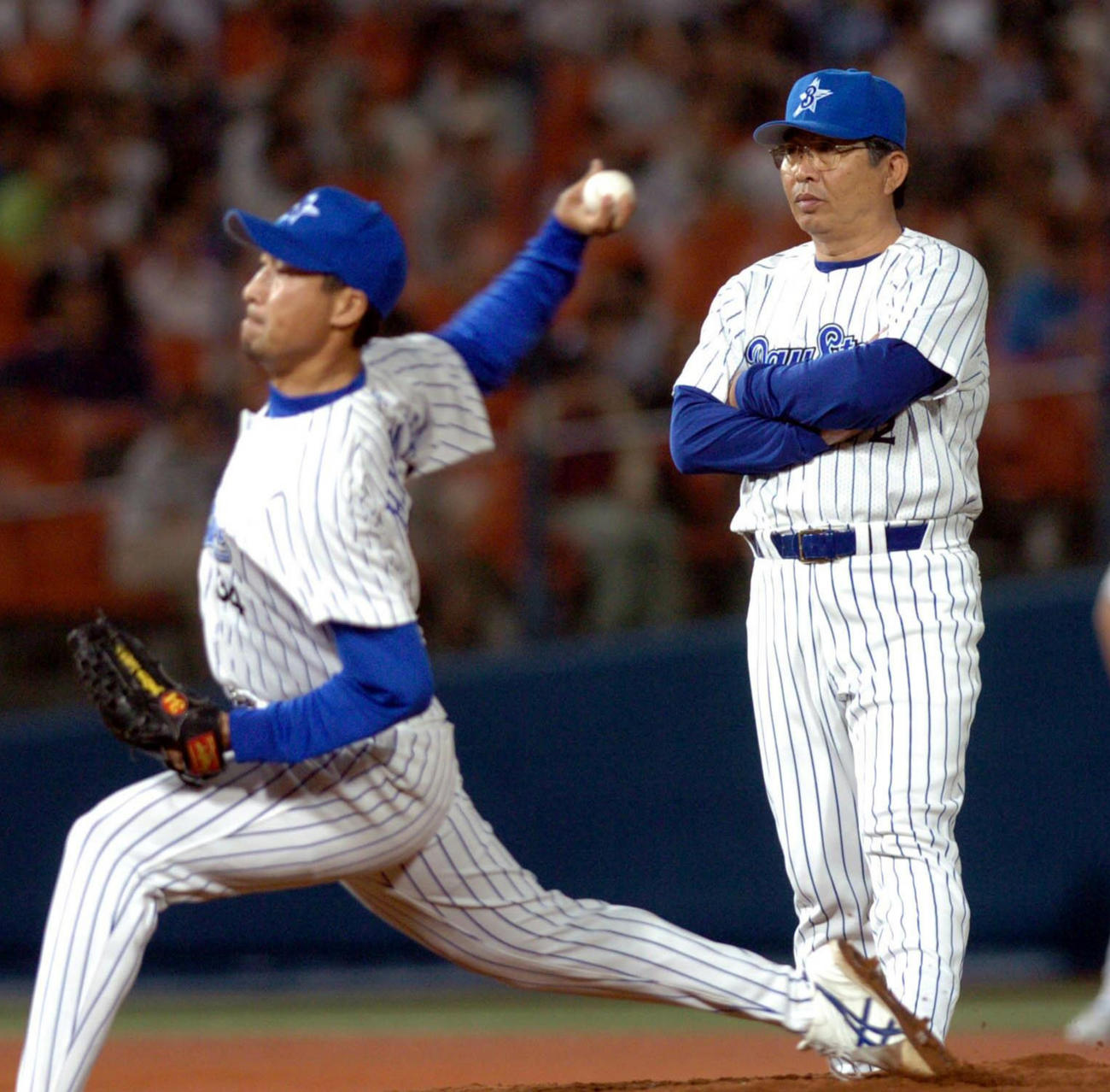 04年6月、巨人戦で投手交代の際に投球練習を見つめる横浜の小谷正勝投手コーチ（右）